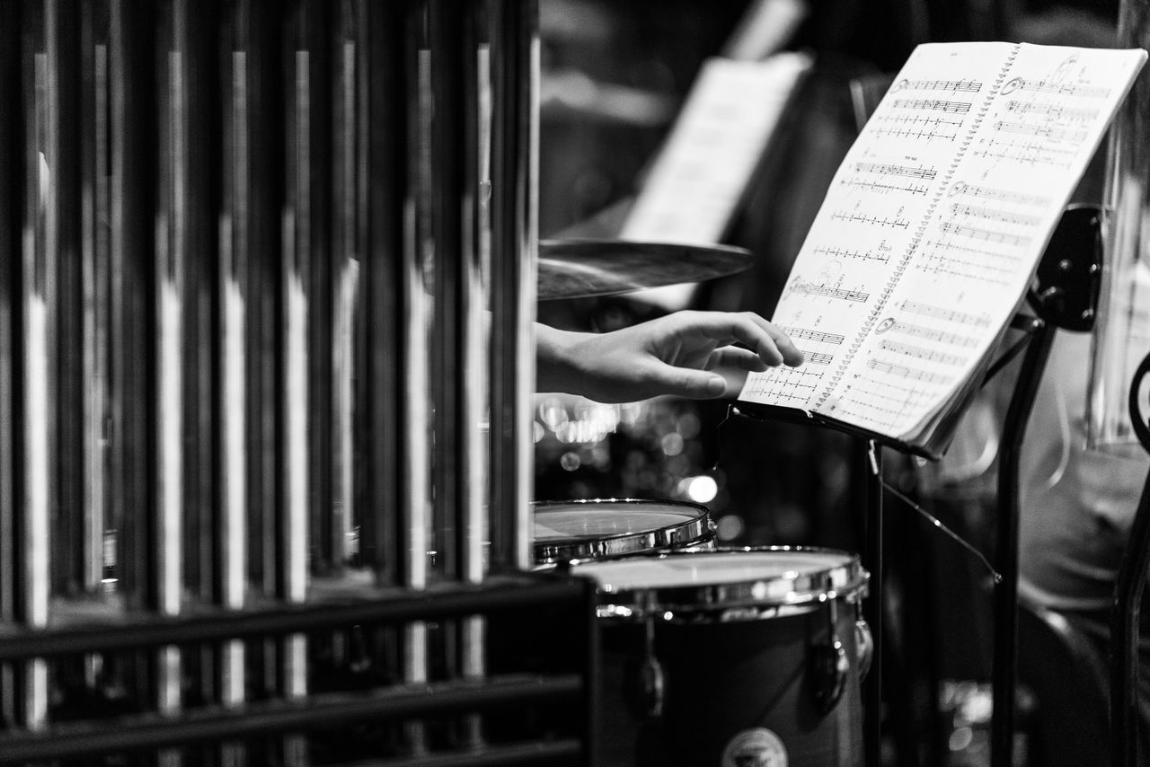 Crafting Captivating Headlines: Your awesome post title goes here Monochrome image of a hand reaching for sheet music in a percussion setup.